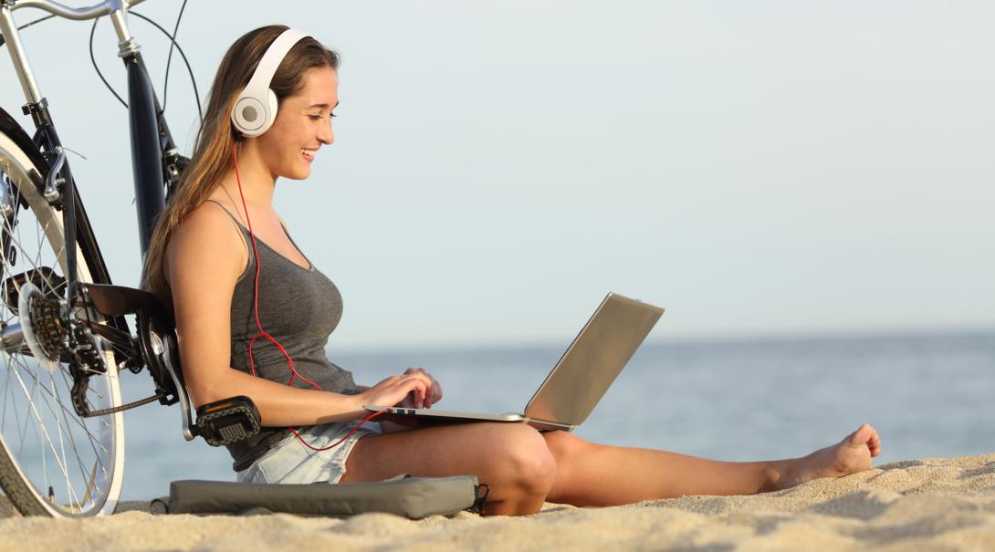 A Backpack University student working at the beach A Backpack University student accessing her notes and working online while at the beach